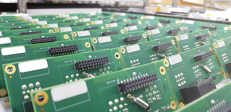 Close up photo of several printed circuit boards in a tray waiting to be shipped.