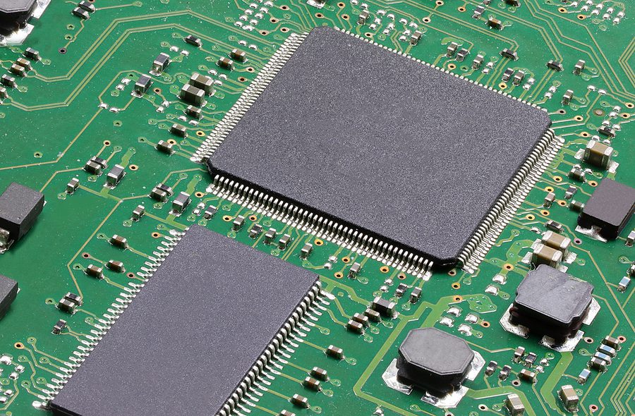 Close-up photo of a green printed circuit board with SMT and Through Hole. 