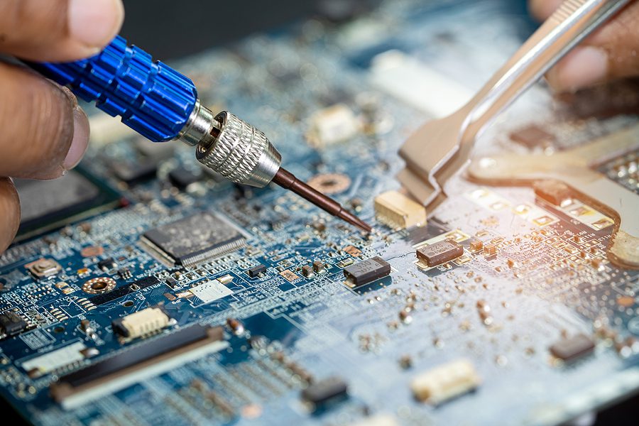 close up photo of technician working on a printed circuit board 