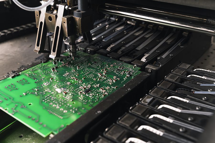 machine manufacturing a printed circuit board at electronic manufacturing plant